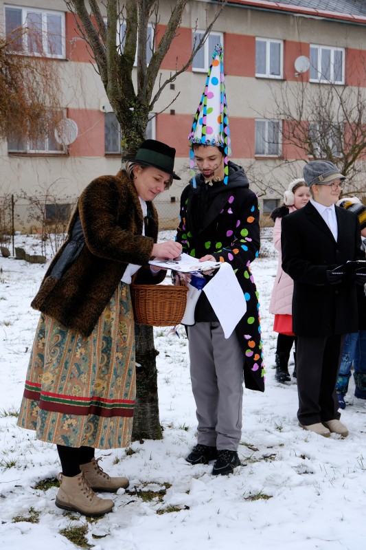 Paní starostka uděluje souhlas k masopustnímu průvodu vesnicí a slavnostně potvrzuje listinu razítkem.